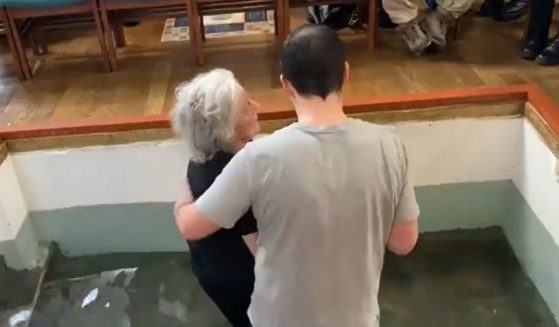 Pastor Regan Blanton King of Grace Baptist Church in the Wood Green district of London baptizes a frail 77-year-old woman named Susan.