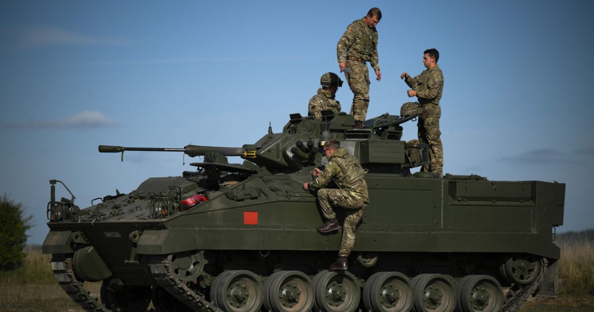 British military personnel are seen on a Warrior armored fighting vehicle during a live fire five-week combat training course with Ukrainian recruits near Durrington, England, on Oct.11, 2022.