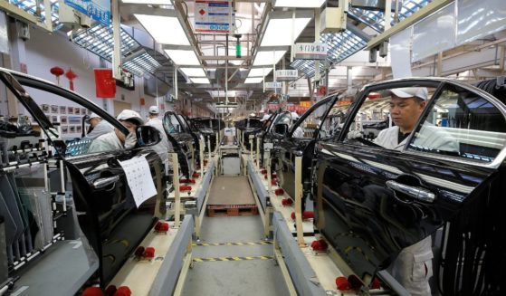 Chinese employees work on a production line of automobiles at a factory in Changchun in China's northeastern Jilin province.