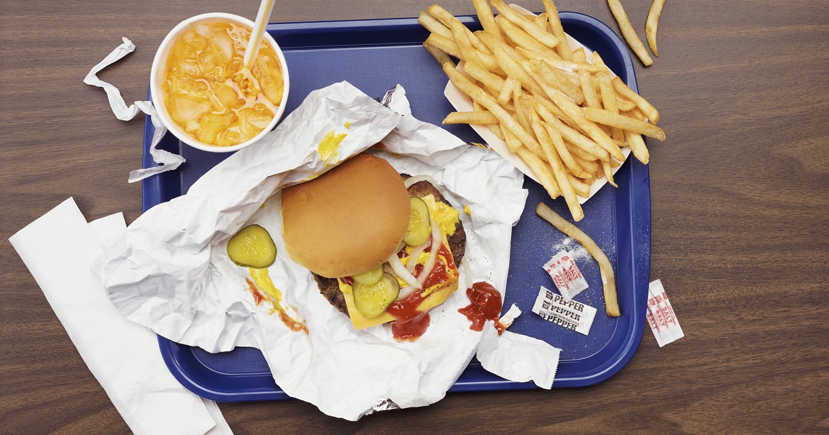 A stock photo shows a food tray with a burger, fries, and a drink.