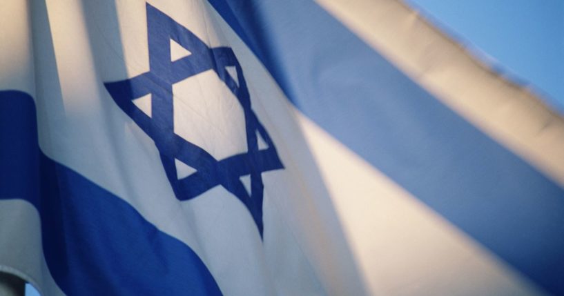 The Israeli flag flies in the above stock image.