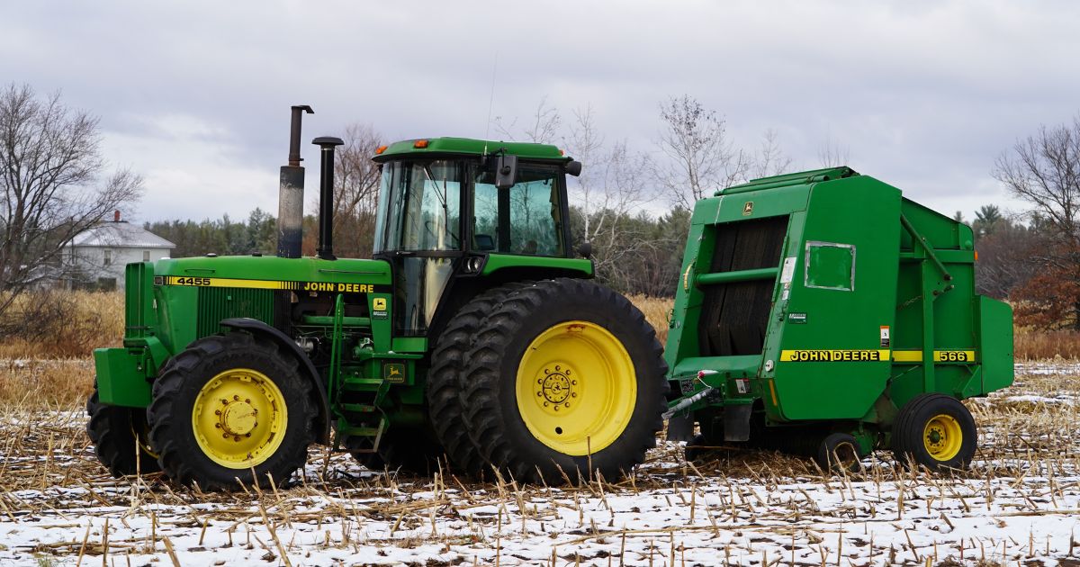 A John Deere 4455 tractor is connected with a 566 hay baler on farmland in New Lisbon, Wisconsin, on Nov. 18.