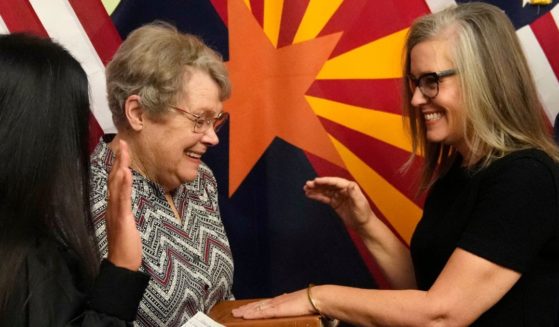 Katie Hobbs, right, laughs while taking the oath of office as Arizona's next governor during a ceremony with her mother, Linda Hobbs, left, at the state Capitol in Phoenix on Monday.