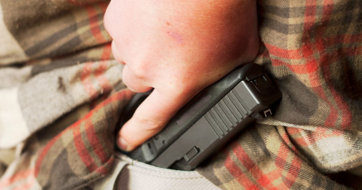 This stock photo shows a man pulling a handgun from inside his waistband. (Ron Bailey / Getty Images)