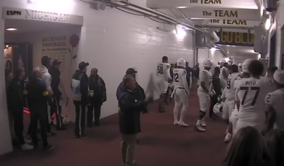 Michigan and Michigan State football players in the tunnel after a game