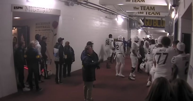 Michigan and Michigan State football players in the tunnel after a game