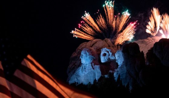 A U.S. flag flies in the forefront while fireworks are set off over Mount Rushmore National Monument in Keystone, South Dakota, on July 3, 2020.