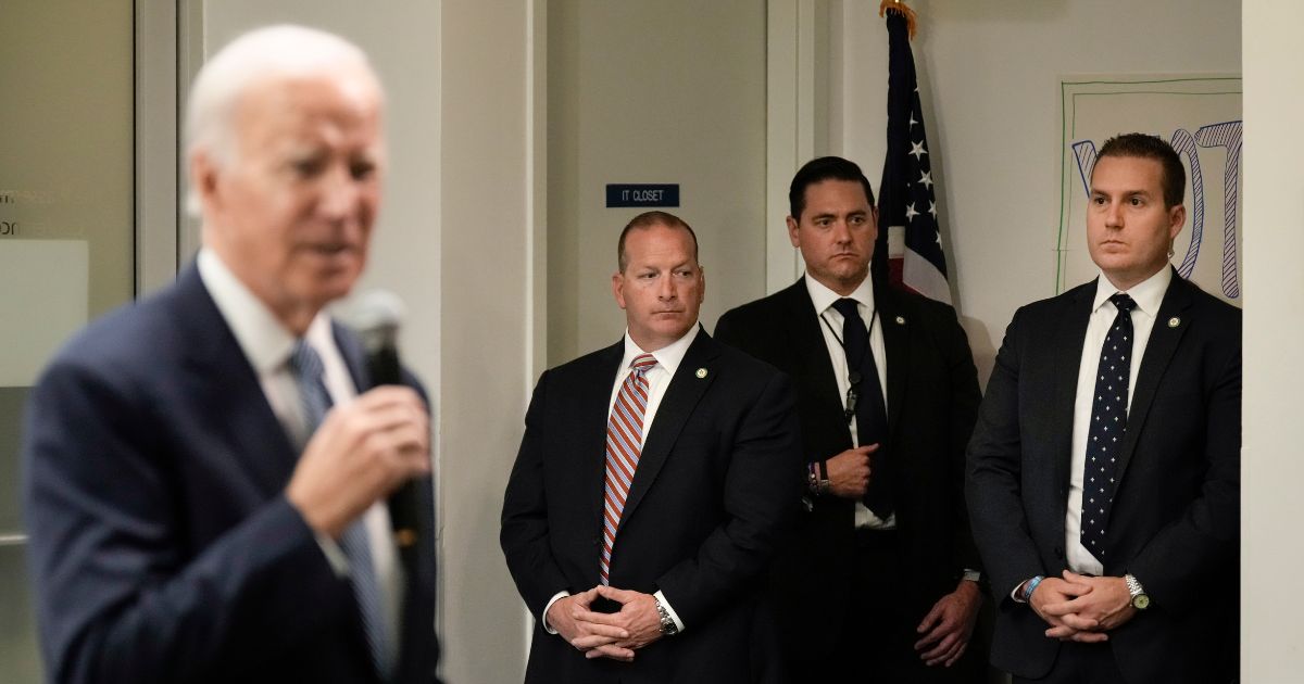 Members of the Secret Service stand watch as President Joe Biden speaks at the headquarters of the Democratic National Committee on Oct. 24, 2022, in Washington, D.C.