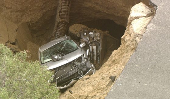 Two vehicles are trapped in a sinkhole that opened in a road in the Chatsworth neighborhood of Los Angeles.