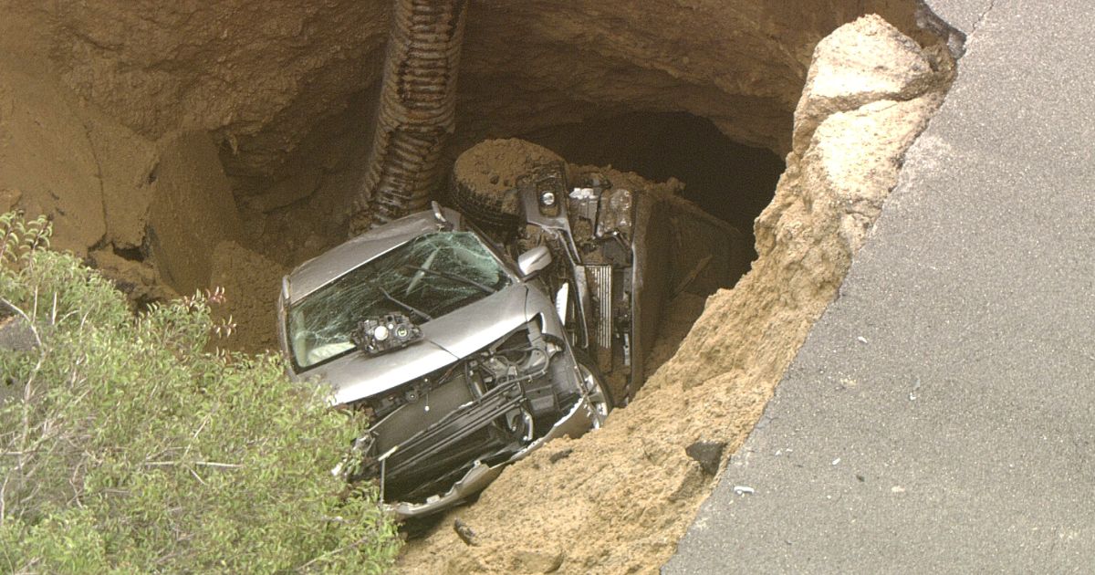 Two vehicles are trapped in a sinkhole that opened in a road in the Chatsworth neighborhood of Los Angeles.