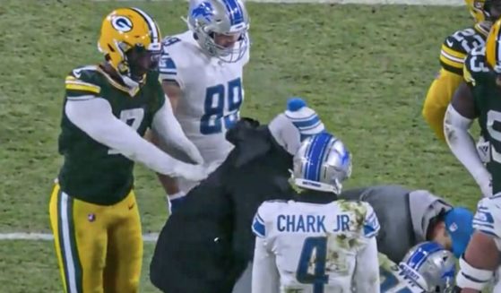 Green Bay Packers linebacker Quay Walker shoves a Detroit Lions trainer during a game Sunday night.