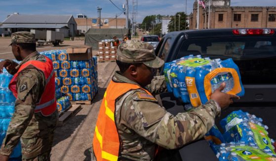 A member of the National Guard places a case of water in the back of a vehicle at the State Fair Grounds in Jackson, Mississippi, on Sept. 2. A failing infrastructure has caused multiple water crises in the city in recent years, often leaving residents without clean running water.
