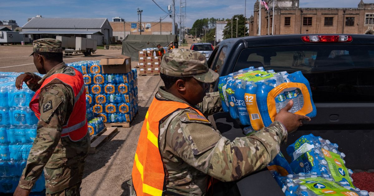 A member of the National Guard places a case of water in the back of a vehicle at the State Fair Grounds in Jackson, Mississippi, on Sept. 2. A failing infrastructure has caused multiple water crises in the city in recent years, often leaving residents without clean running water.