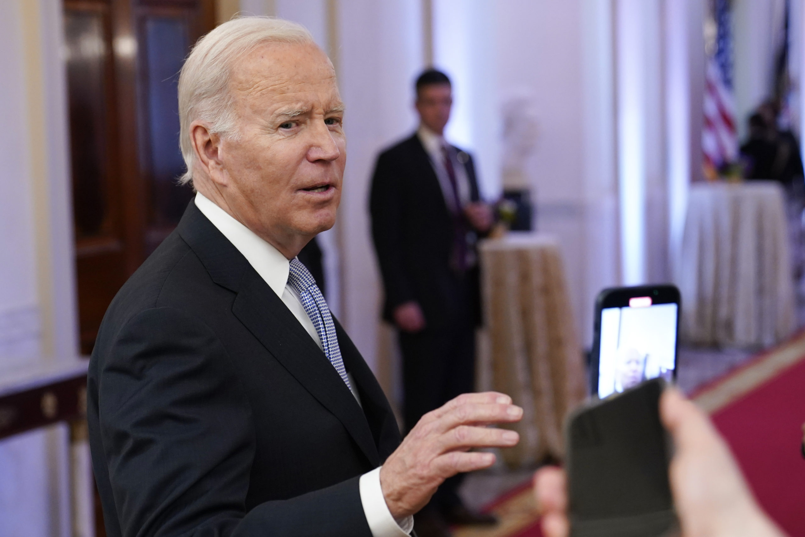 President Joe Biden talks with reporters after speaking in the East Room of the White House on Friday.