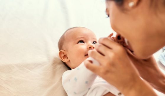 A mother plays with her baby in the above stock image.