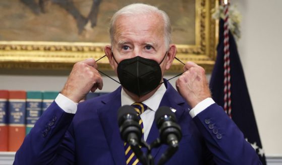 President Joe Biden removes his mask before speaking on student loan debt in the Roosevelt Room of the White House on Aug. 24, 2022, in Washington, D.C.