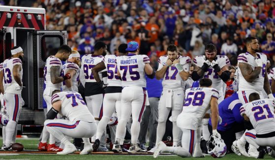 Buffalo Bills players console each other and pray as an ambulance waits to remove defensive player Damar Hamlin after he suffered a cardiac arrest on the field during the first quarter of play against the Cincinnati Bengals on Monday night at Paycor Stadium in Cincinnati.