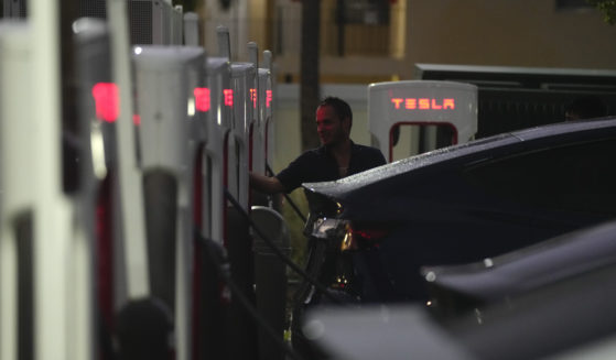 A driver charges his car at a Tesla Supercharger station in Miami in November. (AP / Rebecca Blackwell)