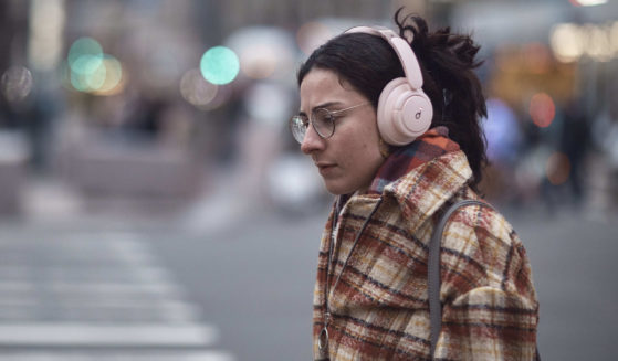A woman using headphones walks in New York City on Tuesday.