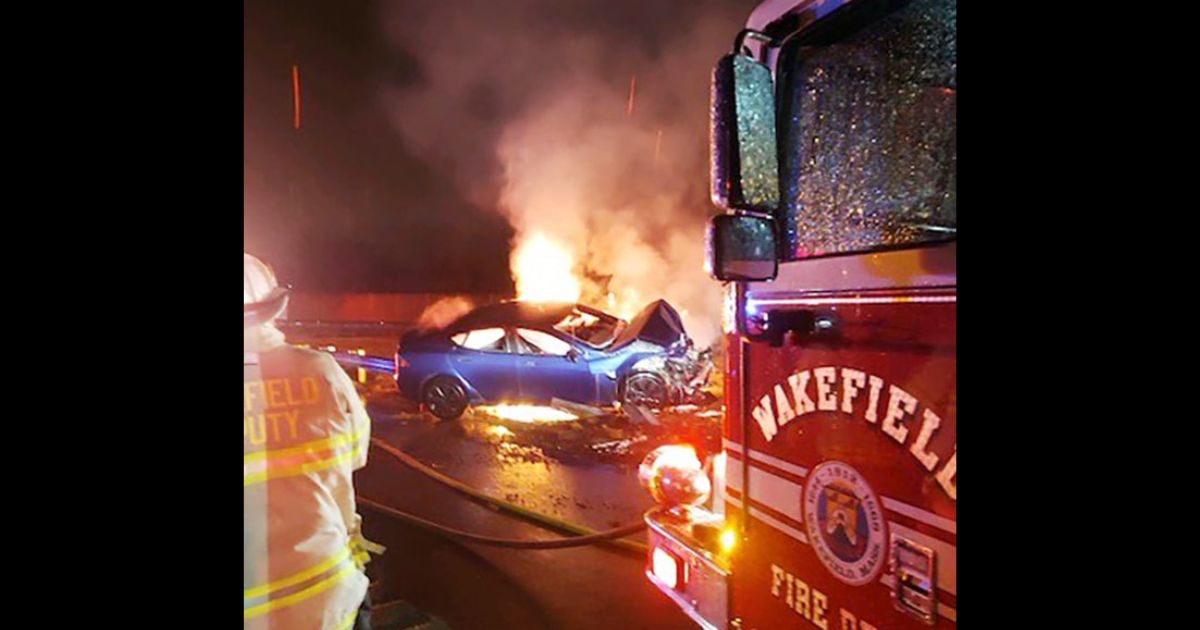 Firefighters work to put out an electric vehicle fire in Wakefield, Massachusetts, on Thursday.