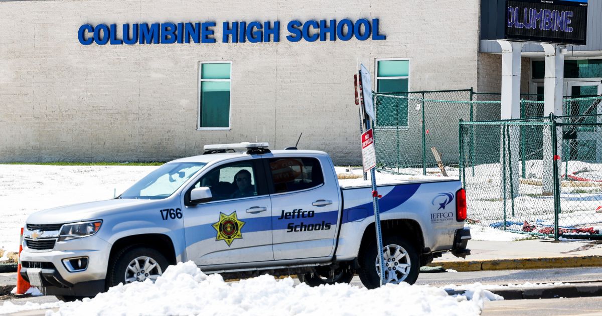 Police officers sit in the parking lot next to Columbine High School on April 20, 2021, in Littleton, Colorado.