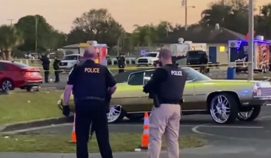 Two police officers standing at the scene after a shooting at Ilous Ellis Park in Fort Pierce, Florida