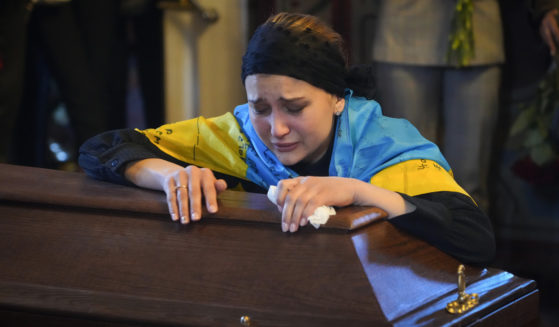 The widow of Ukrainian journalist and volunteer soldier Oleksandr Makhov cries over his coffin at St. Michael cathedral in Kyiv, Ukraine, on May 9.