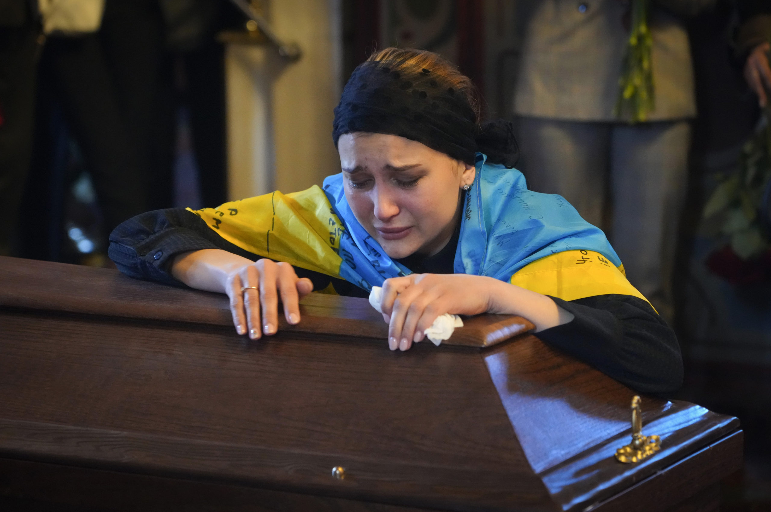 The widow of Ukrainian journalist and volunteer soldier Oleksandr Makhov cries over his coffin at St. Michael cathedral in Kyiv, Ukraine, on May 9.