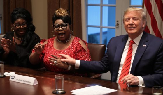 Former President Donald Trump, right, listens as Lynette "Diamond" Hardaway, left, and Rochelle "Silk" Richardson praise him during a news conference and meeting with African American supporters in the Cabinet Room at the White House on Feb. 27, 2020, in Washington, D.C.