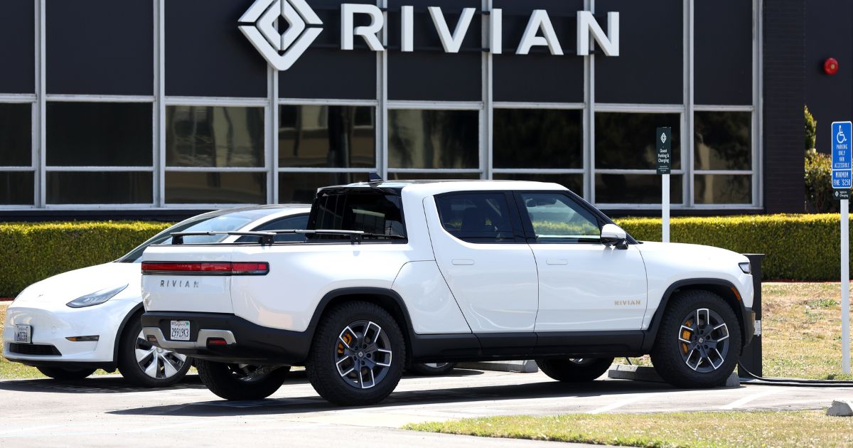 A Rivian electric pickup truck sits in a parking lot at a Rivian service center on May 9, 2022, in South San Francisco.