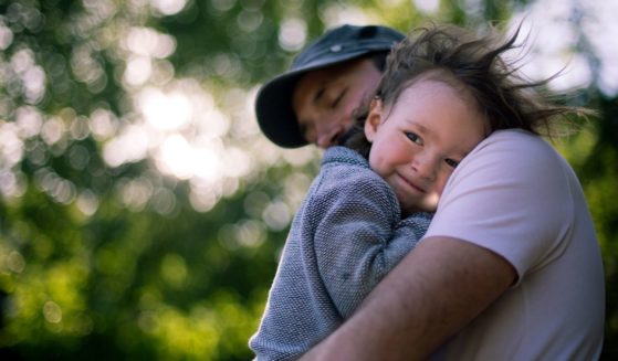 A father holds his son in the above stock image.