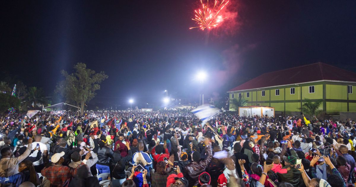 Fireworks light up the sky as people react while they celebrate after counting down to the new year at Miracle Center Cathedral in Kampala, Uganda, on Sunday.