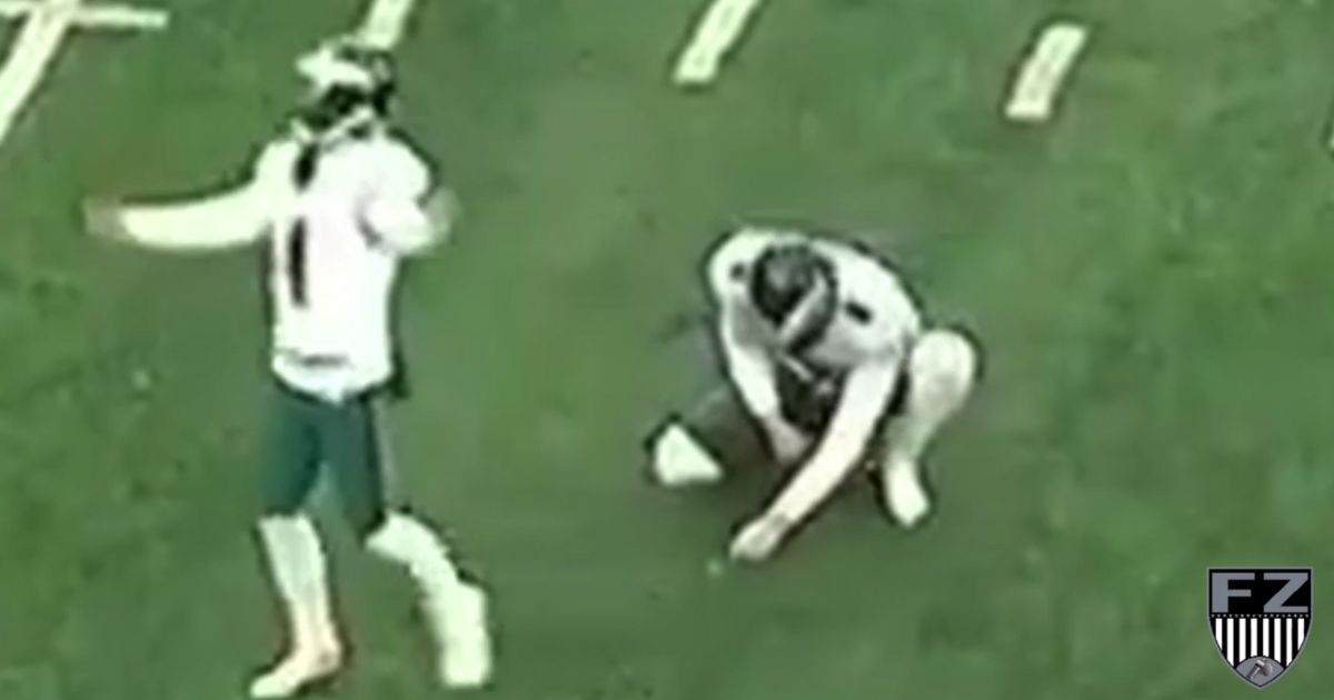 Philadelphia Eagles holder Britain Covey appears to pick up a small white object after the ball was kicked by Jake Elliott.