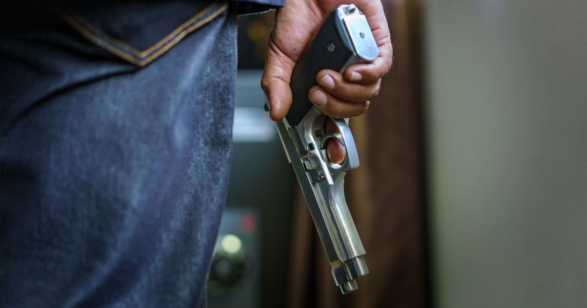 A man holding a handgun is featured in this stock photo.