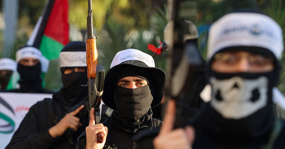 Palestinians Hamas militants wearing headbands reading in Arabic "the Lion's Den", in reference to the Nablus based Lion's Den armed group (Areen Al-Asood), a loose coalition of fighters not aligned with established Palestinian factions, march in support of the group in Gaza City on December 10, 2022.