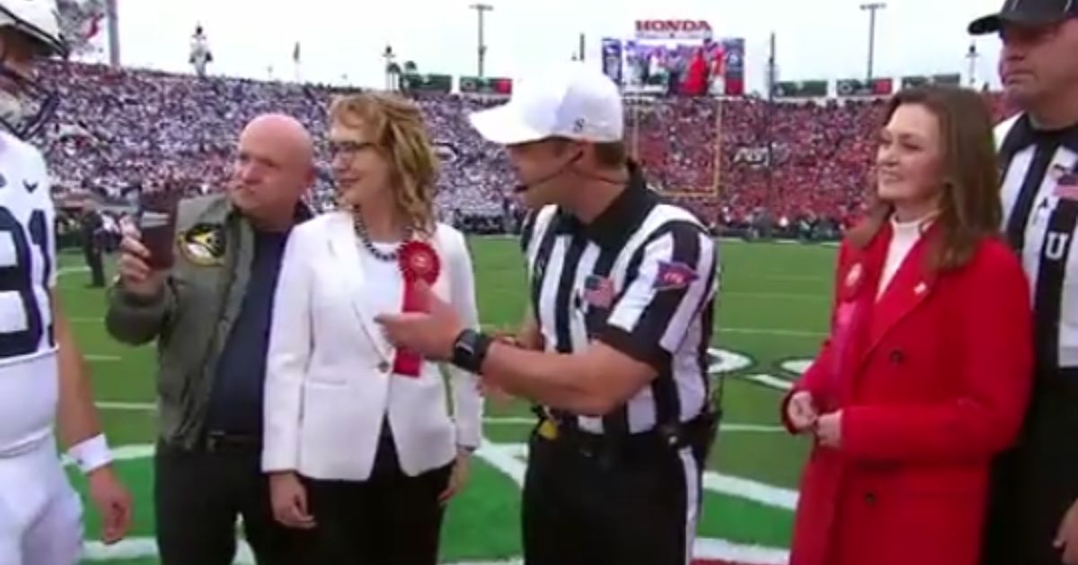Sen. Mark Kelly of Arizona videos the coin toss of Monday's Rose Bowl.