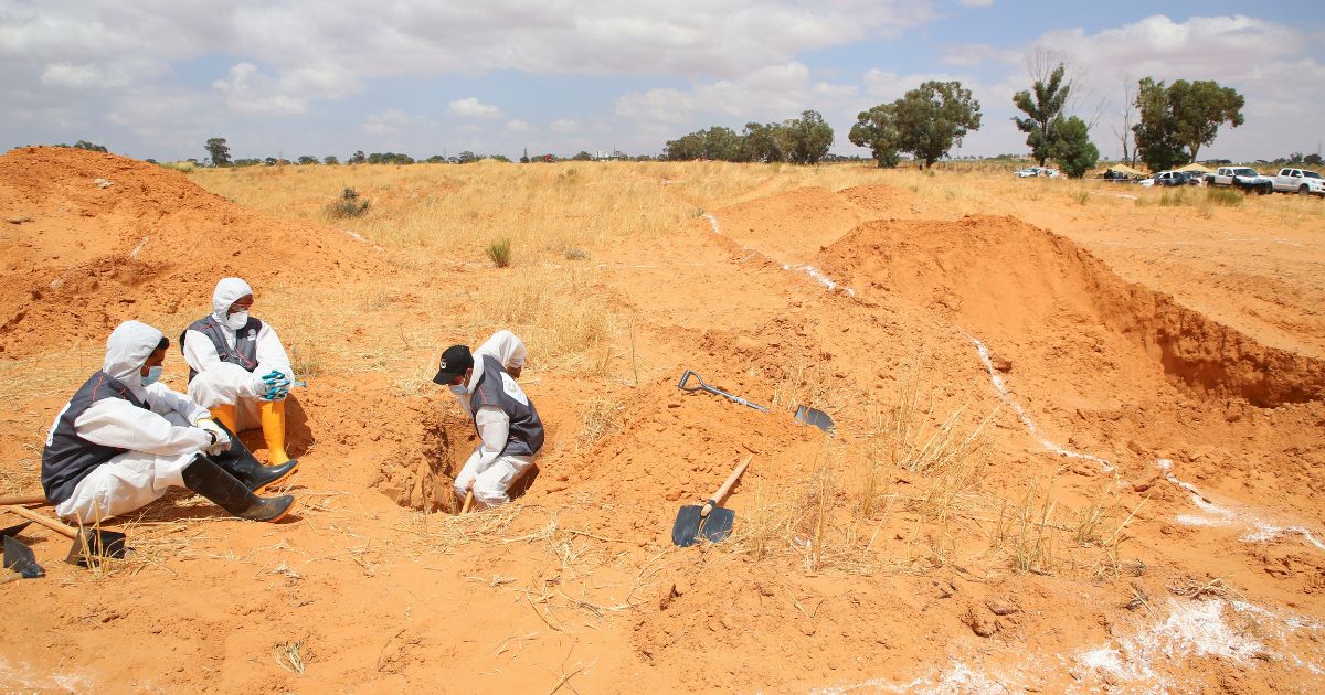 Libyan Ministry of justice employees dig out at a siyte of a suspected mass grave in the town of Tarhouna, Libya, on June 23, 2020.