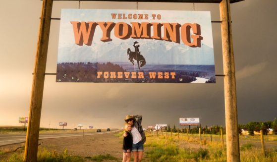The above image is of two individuals with a Wyoming sign.