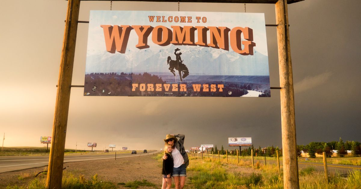 The above image is of two individuals with a Wyoming sign.