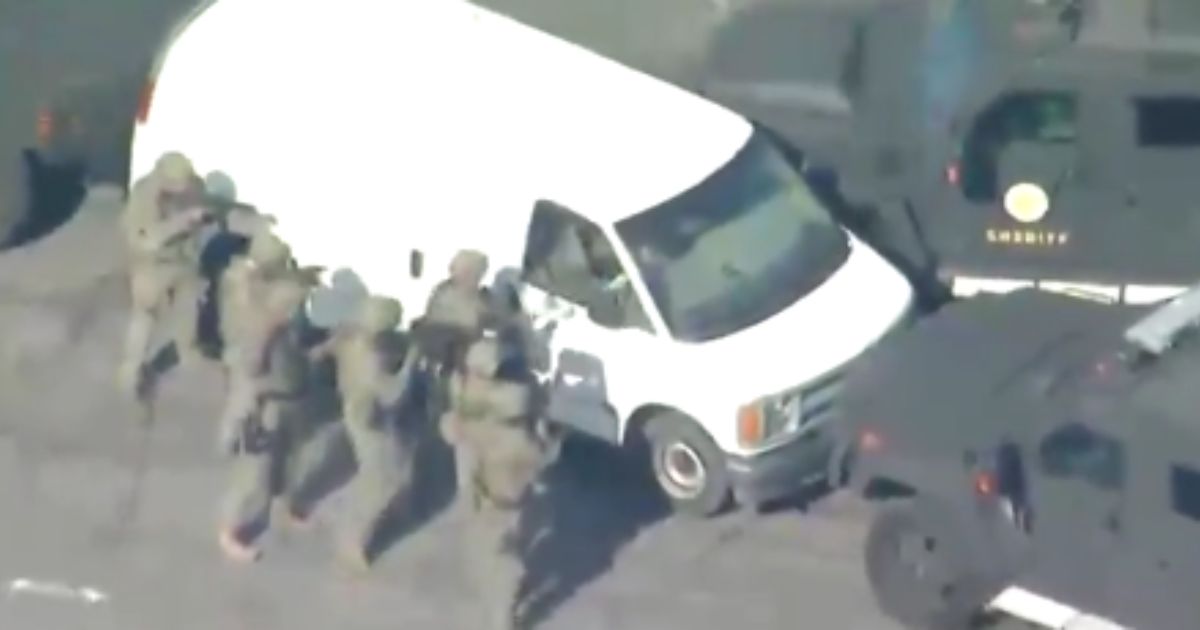 Law enforcement enter a white van after the Lunar New Year shooting in Monterey Park, California.
