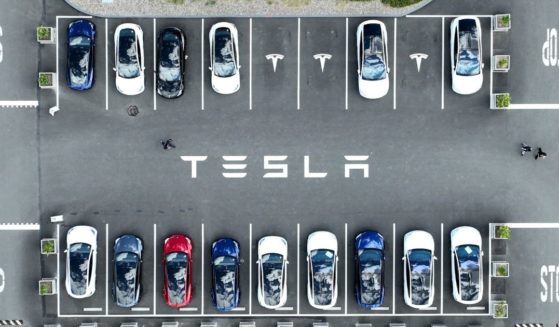 In an aerial view, Tesla cars sit parked in a lot at the Tesla factory on April 20, 2022, in Fremont, California.