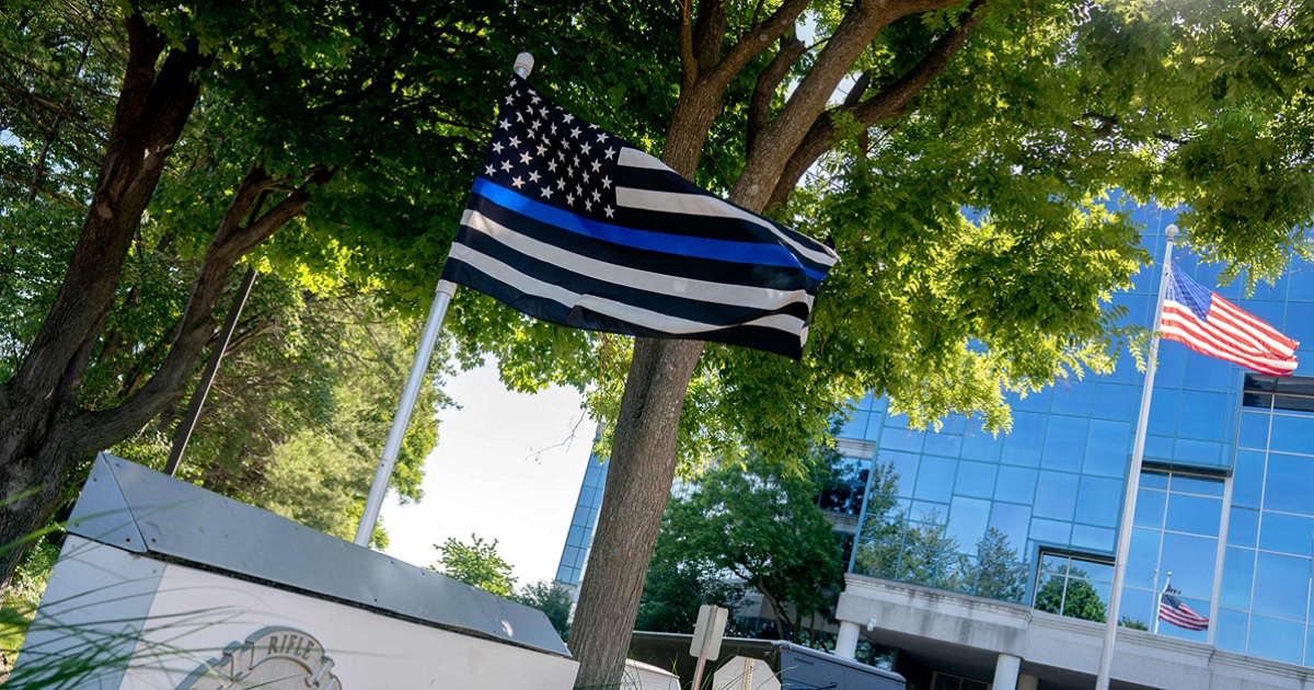 A "thin blue line" flag, signaling support for law enforcement, is displayed above the sign for the National Rifle Association outside of its headquarters in Fairfax, Virginia, in May.