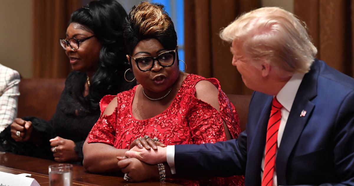 Former President Donald Trump reacts as social media personalities Lynnette Hardaway and Rochelle Richardson, otherwise known as Diamond and Silk, speak during a meeting with African-American leaders in the Cabinet Room of the White House in Washington, D.C., on Feb. 27, 2020.