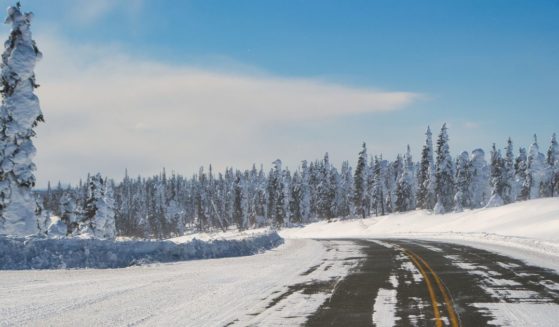 A snowy road is seen in the above stock image.