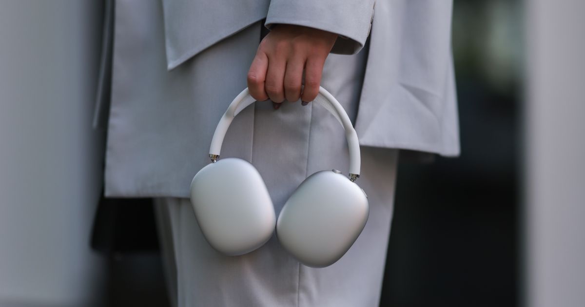 A woman holds a silver pair of Apple AirPods Max, which have become the target of a group of thieves in New York City.