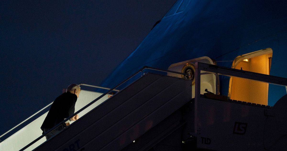 U.S. President Joe Biden stumbles while boarding Air Force One in Warsaw, Poland, on Wednesday.
