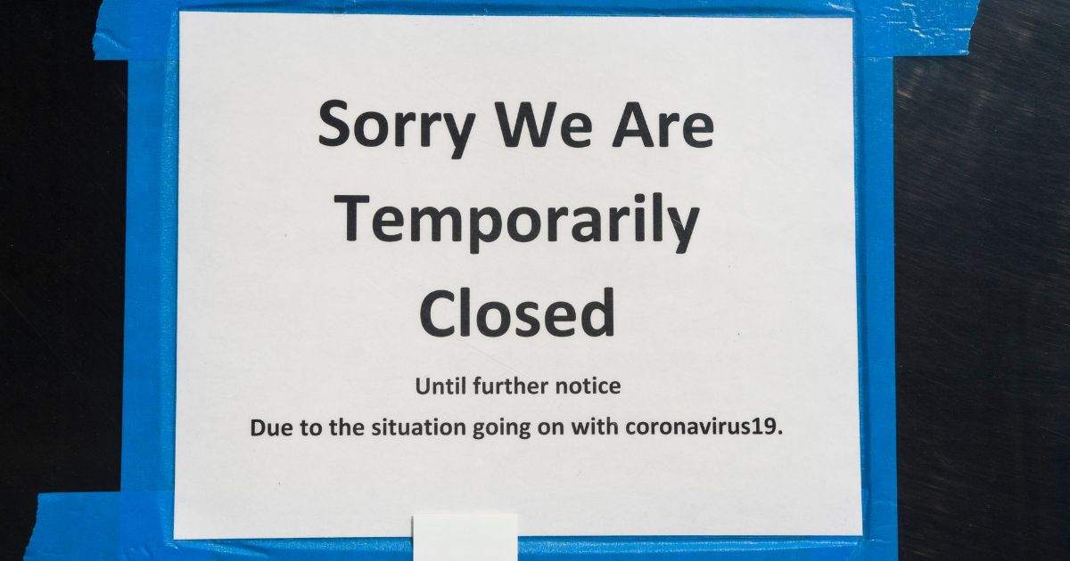 A closed sign hangs outside of a business during COVID lockdowns.