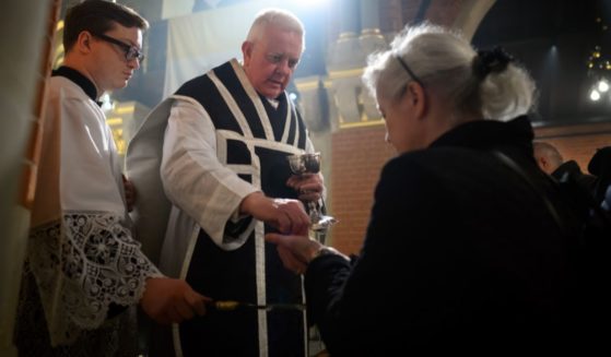 Members of the congregation at Corpus Christi Catholic Church in London, England, receive Holy Communion from Father Alan Robinson on Jan. 5.