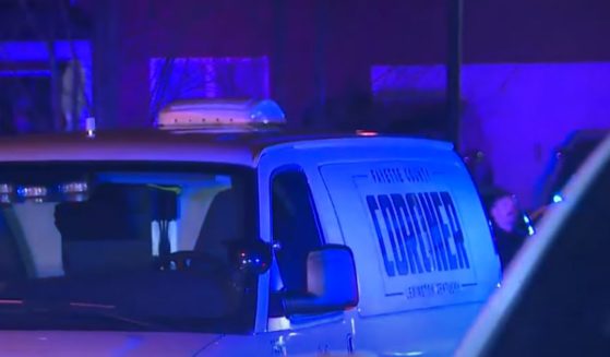 A county coroner's vehicle is at the scene of a fatal shooting early Monday following a home invasion in Lexington, Kentucky.