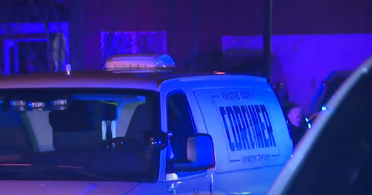 A county coroner's vehicle is at the scene of a fatal shooting early Monday following a home invasion in Lexington, Kentucky.